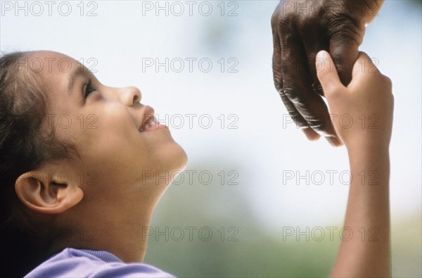 Young girl holding adult's hand. Photo : Fisher Litwin