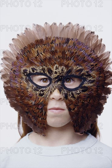 Child wearing a feather mask. Photo : Fisher Litwin