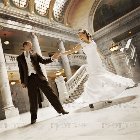 Bride and groom holding hands in mansion. Photo : FBP