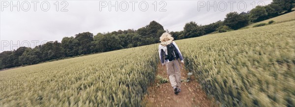 Hiker walking on path through field. Photo : Fisher Litwin