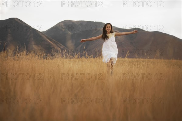 Girl (10-11) running through wheat field. Photo : FBP