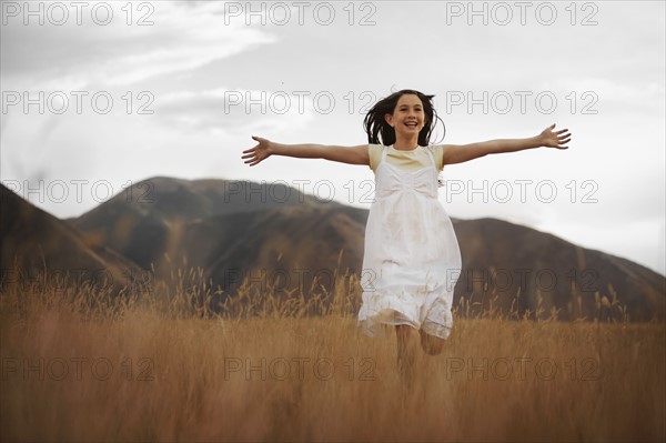 Girl (10-11) running through wheat field. Photo : FBP