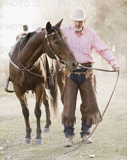 Portrait of senior man with horse in ranch. Photo : Mike Kemp