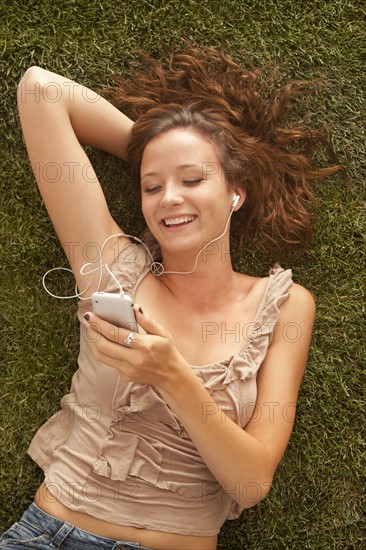 Young girl (16-17) lying on grass. Photo : Mike Kemp