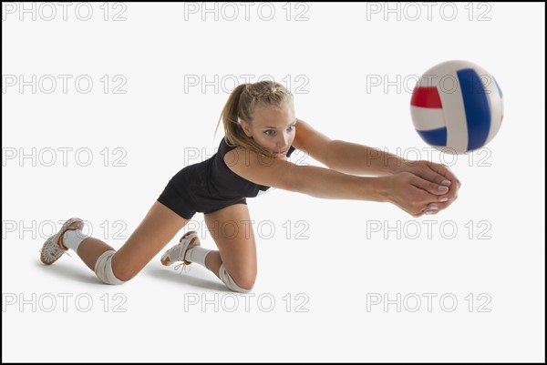 Young girl (16-17) playing volleyball. Photo : Mike Kemp