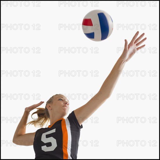 Young girl (16-17) playing volleyball. Photo : Mike Kemp