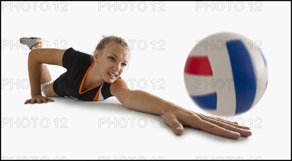 Young girl (16-17) playing volleyball. Photo : Mike Kemp