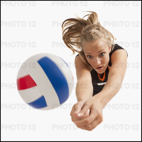 Young girl (16-17) playing volleyball. Photo : Mike Kemp