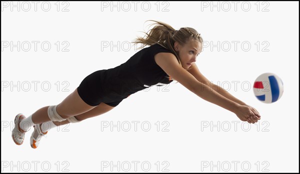 Young girl (16-17) playing volleyball. Photo : Mike Kemp