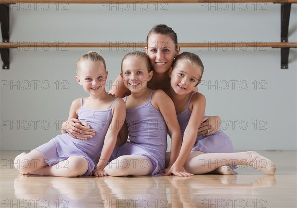 Portrait of female instructor with ballet dancers (6-7) in dance studio. Photo : Mike Kemp