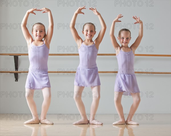 Portrait of three ballet dancers (6-7) in dance studio. Photo : Mike Kemp