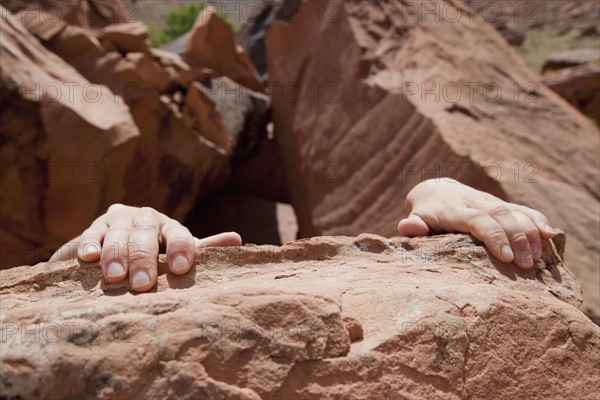 Young woman's hands on rocks. Photo : Johannes Kroemer