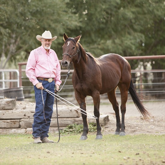 Portrait of senior man with horse in ranch. Photo : Mike Kemp