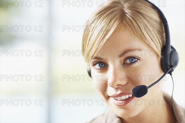 Portrait of young female customer service representative. Photo : Momentimages