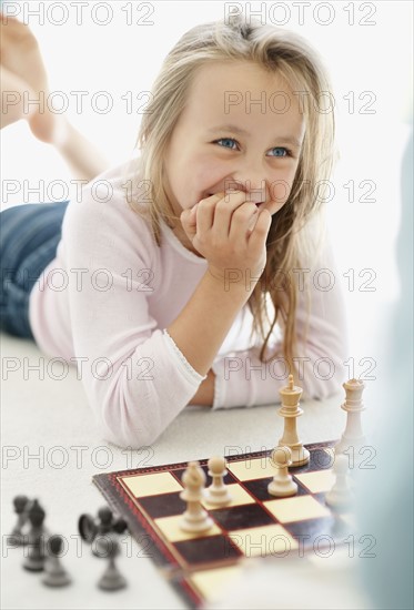 Girl (10-11) playing chess. Photo : Momentimages