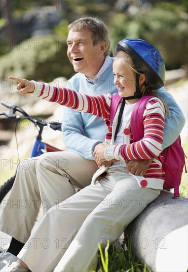 Happy grandfather and granddaughter (10-11) with bike. Photo : Momentimages