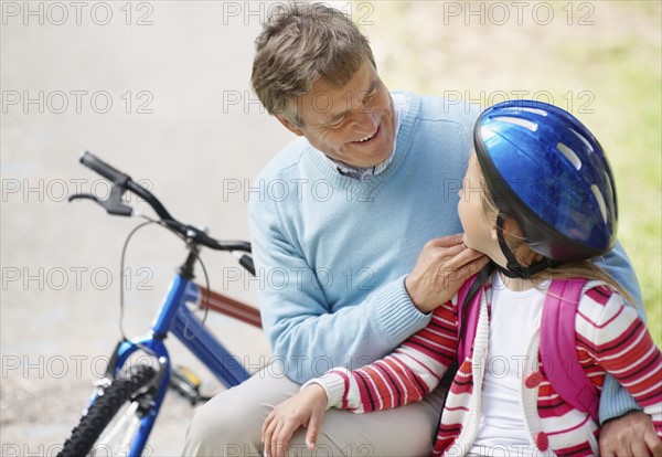 Happy grandfather and granddaughter (10-11) with bike. Photo : Momentimages