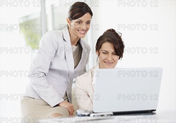 Female office workers using laptop. Photo : Momentimages