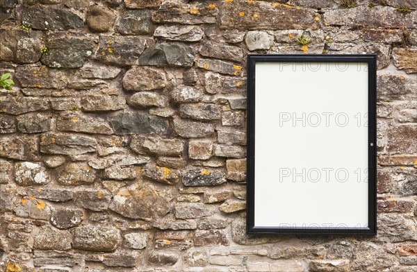 Blank sign on stone wall . Photo : Jon Boyes