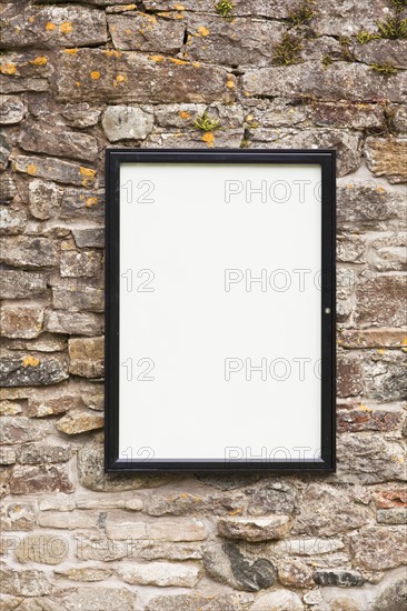 Blank sign on stone wall . Photo : Jon Boyes