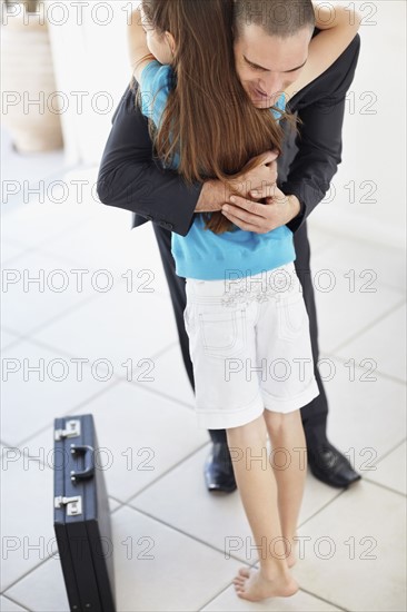 Father coming back from work embracing daughter (10-11). Photo : Momentimages