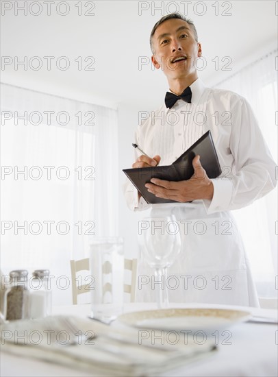 Waiter taking order and looking at camera. Photo : Jamie Grill