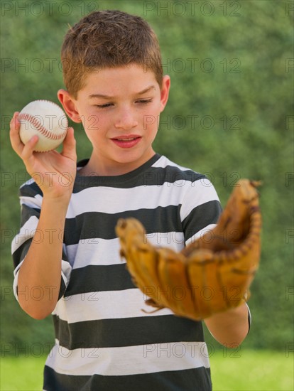 Boy (10-11) holding baseball and baseball glove. Photo : Daniel Grill
