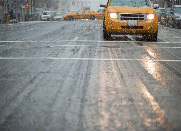 USA, New York, New York City, Yellow cab on street in snow.