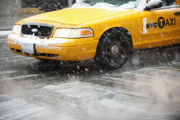 USA, New York, New York City, Close-up of yellow cab on street in snow.