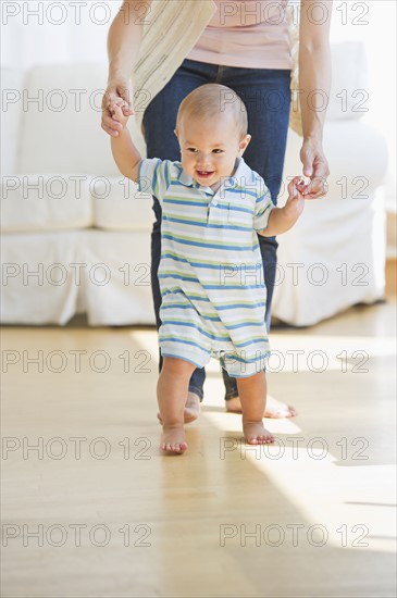 Mother helping son (6-11 months) with first steps. Photo : Daniel Grill