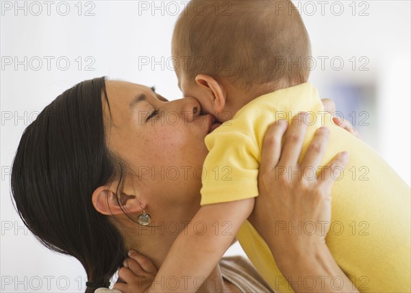 Mother carrying and kissing son (6-11 months). Photo : Daniel Grill