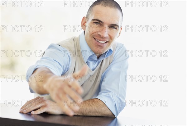 Mid adult man offering hand for handshake. Photo : Momentimages