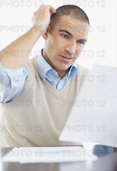 Office worker scratching behind ear. Photo : Momentimages