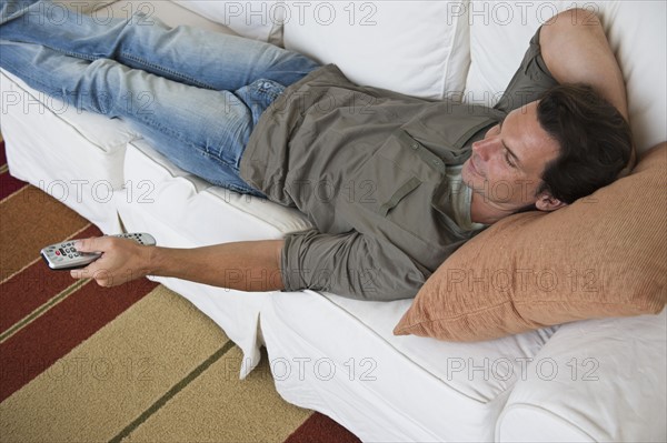 Man relaxing on sofa and watching TV.