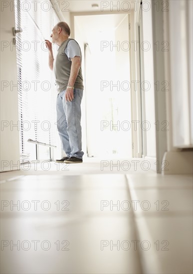 Patient standing in corridor of clinic. Photo : Momentimages