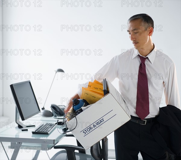 Businessman with his personal belongings in box. Photo : Jamie Grill