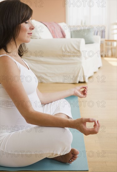 Young pregnant woman meditating. Photo : Jamie Grill