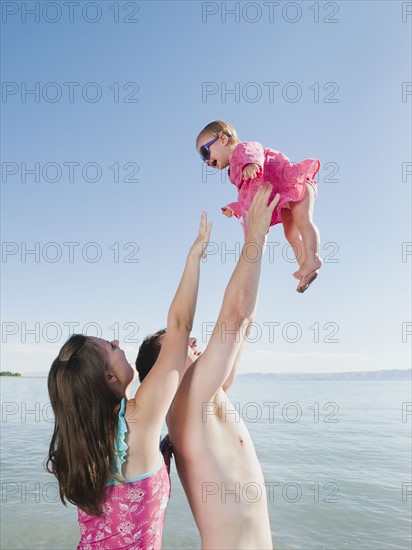 Parents with baby daughter (12-18months) playing on holidays.