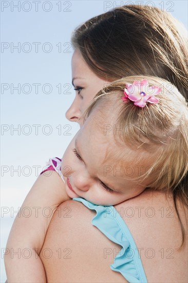 Mother with baby daughter (12-18months) hugging.