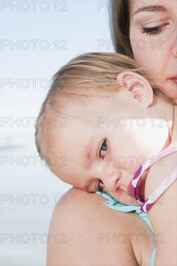 Mother with baby daughter (12-18months) hugging.