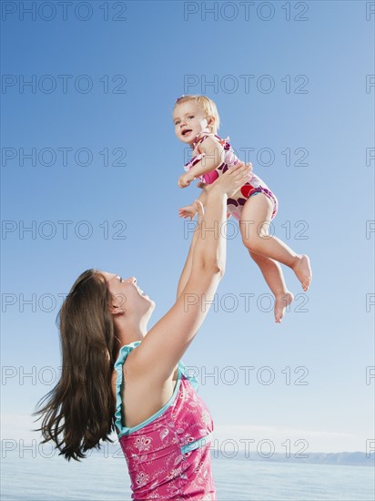 Mother with baby daughter (12-18months) playing on holidays.