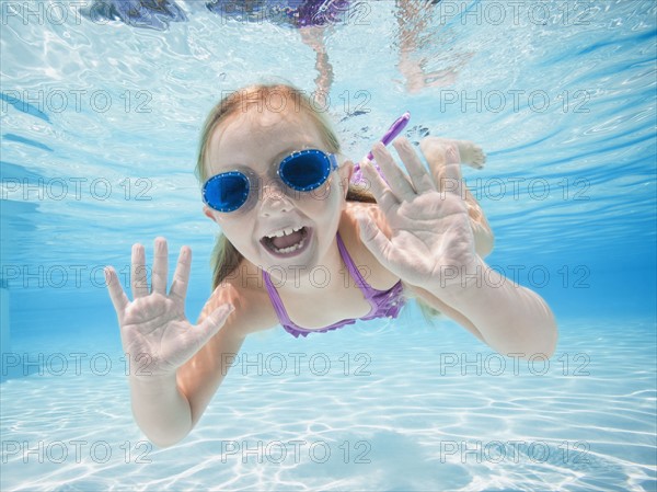 Girl (6-7) swimming underwater.