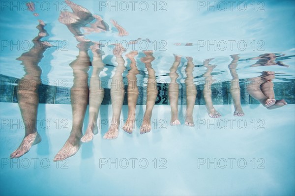 Family with four kids (12-18months, 4-5,6-7,8-9) on swimming pool.