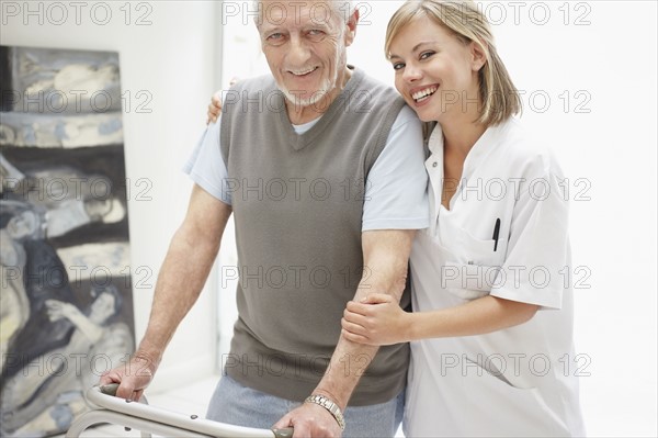 Nurse assisting patient in corridor of clinic. Photo : Momentimages