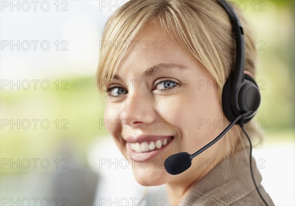 Portrait of young female customer service representative. Photo : Momentimages