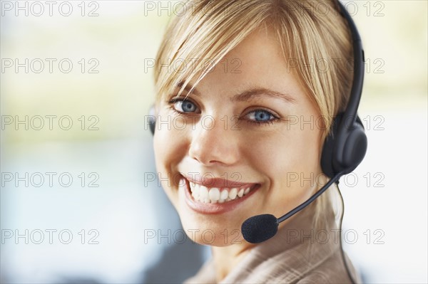 Portrait of young female customer service representative. Photo : Momentimages