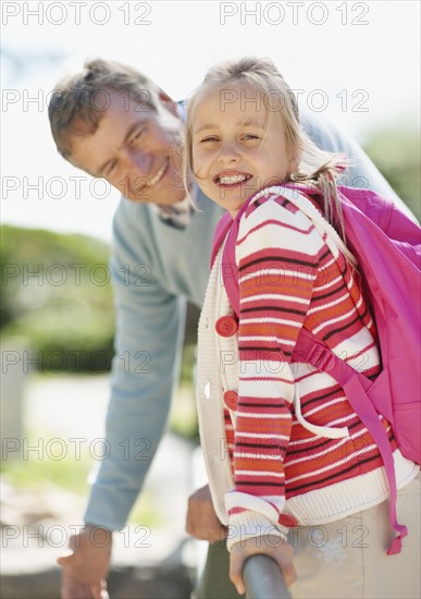 Portrait of smiling grandfather and granddaughter (10-11). Photo : Momentimages