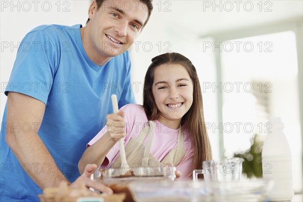Daughter (10-11) helping father prepare food. Photo : Momentimages