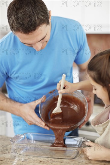 Daughter (10-11) helping father prepare food. Photo : Momentimages