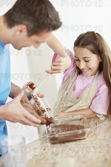 Daughter (10-11) helping father prepare food. Photo : Momentimages